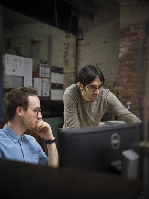 Zwei Personen von IGIT bei der Arbeit vor einem Bildschirm